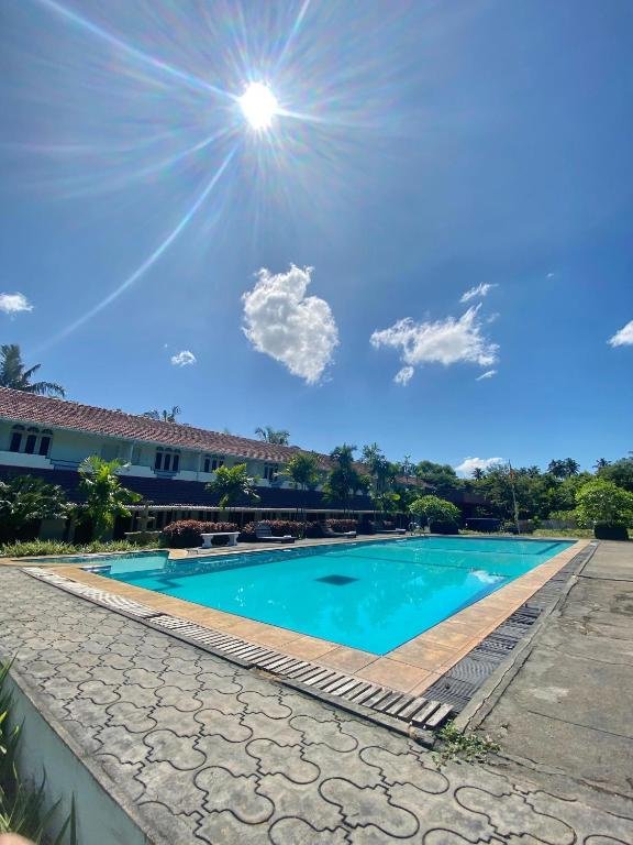 Green Island Hotel and its blue swimming pool surrounded by palms